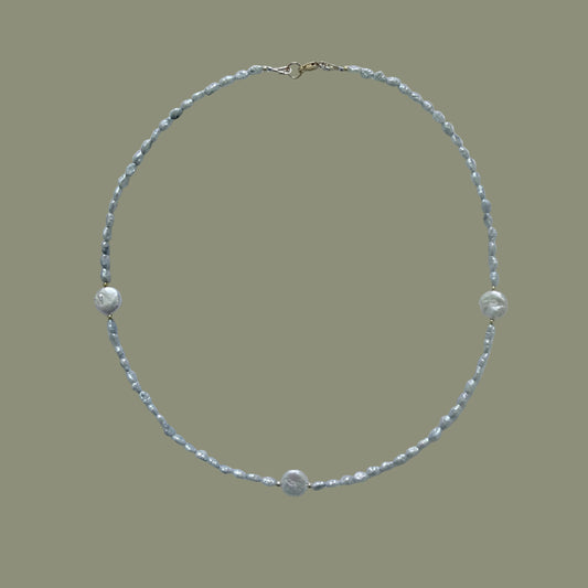 Pearl necklace on a light gray background