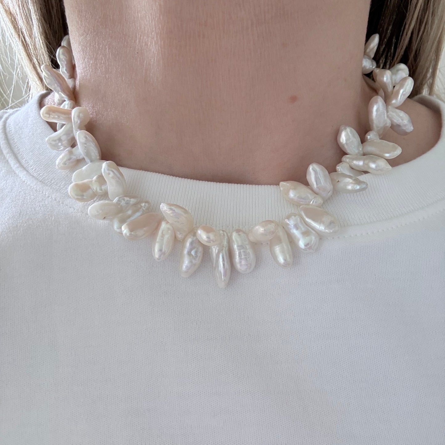 Pearl headband worn by a person on a plain background