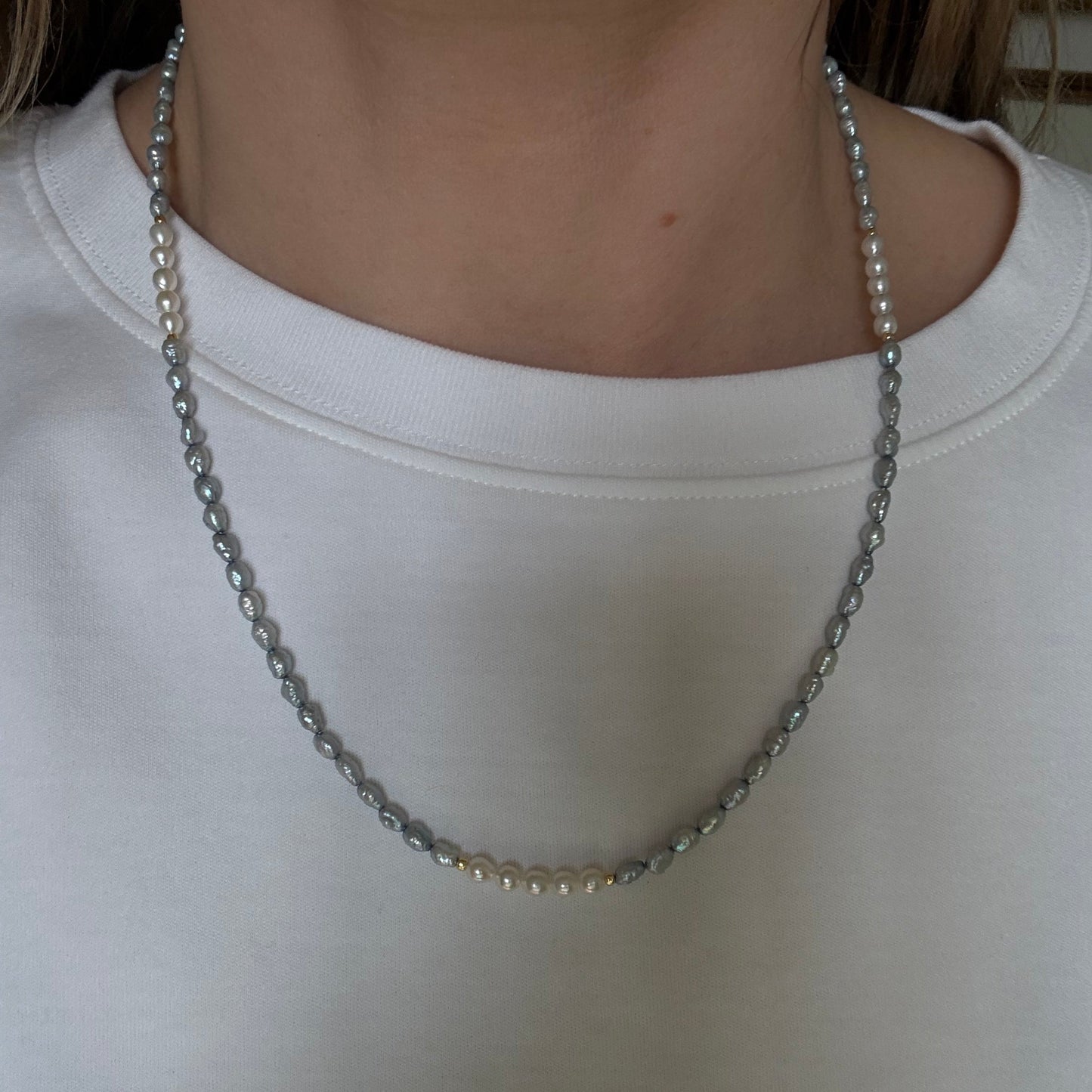 Silver chain necklace on a plain background