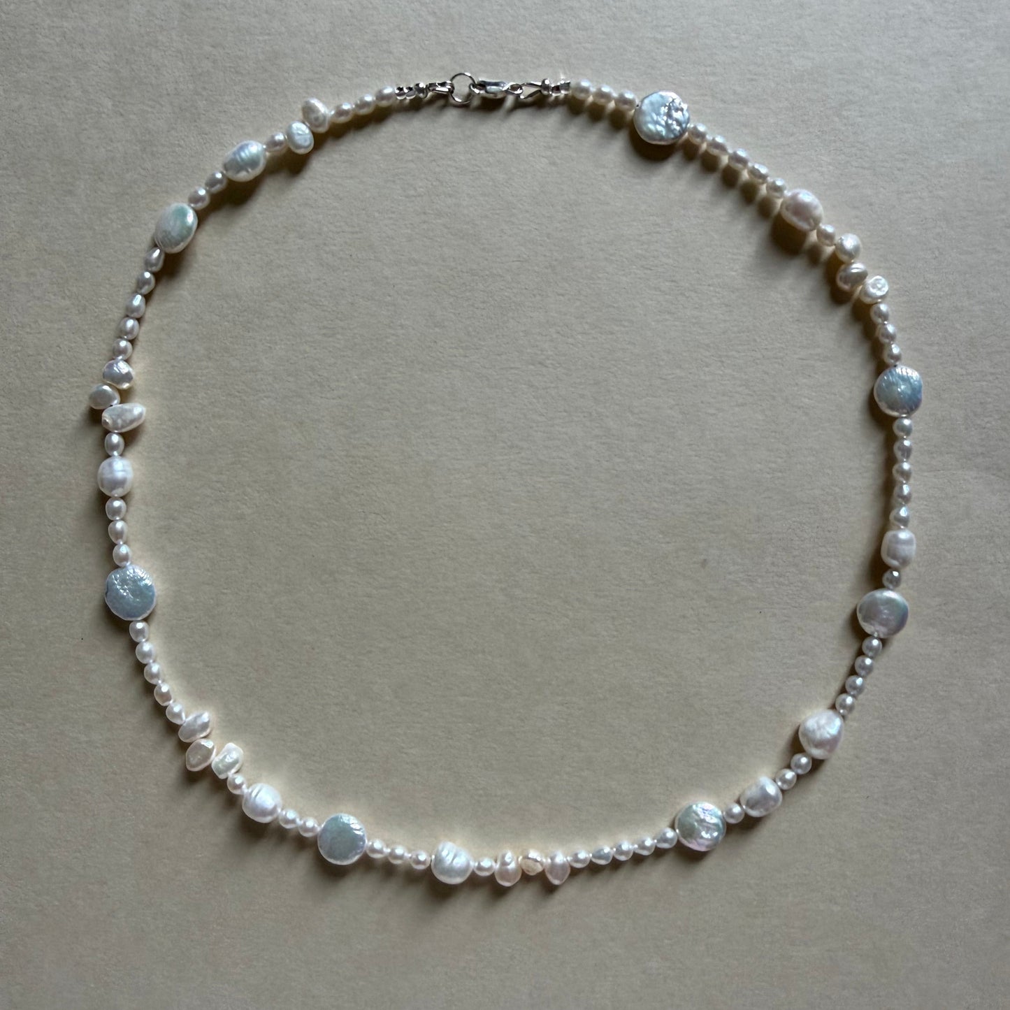 Pearl necklace on a beige background