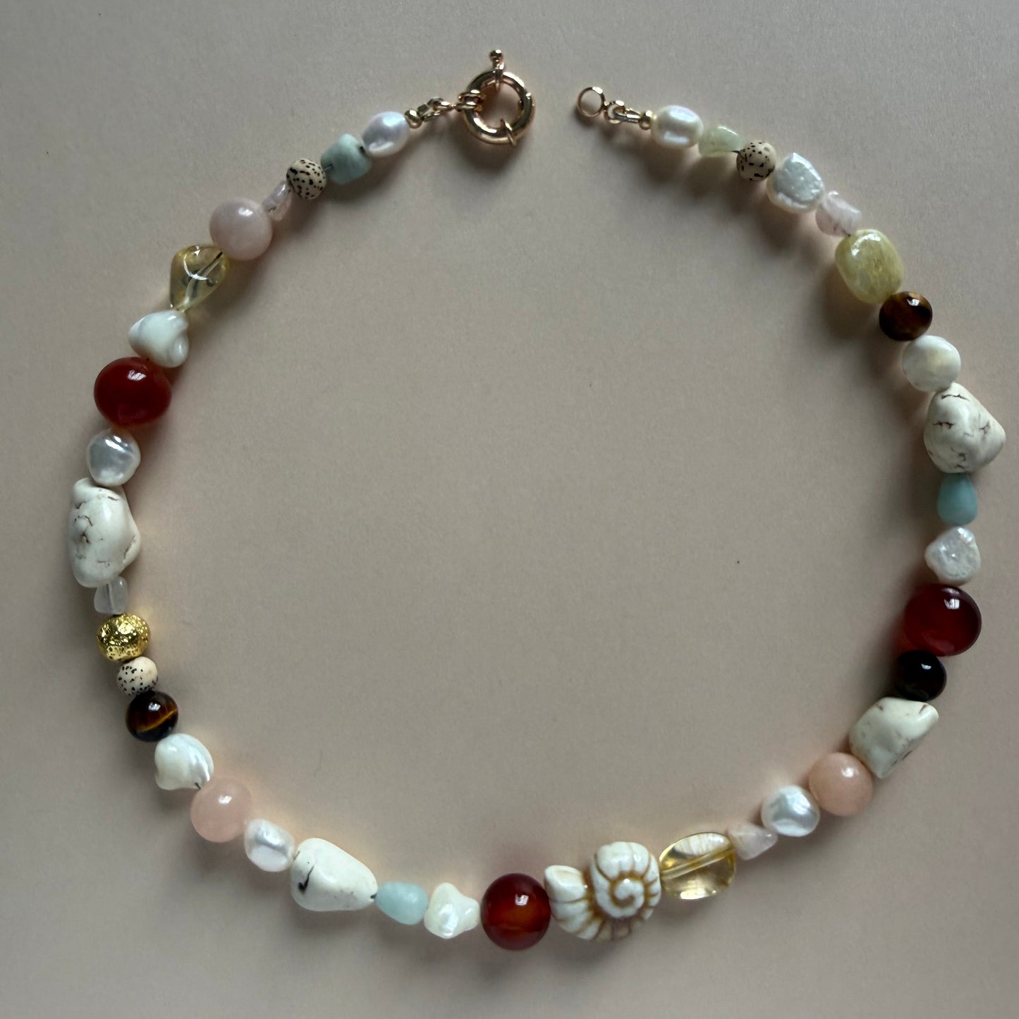 Beaded bracelet with multicolored stones on a beige background