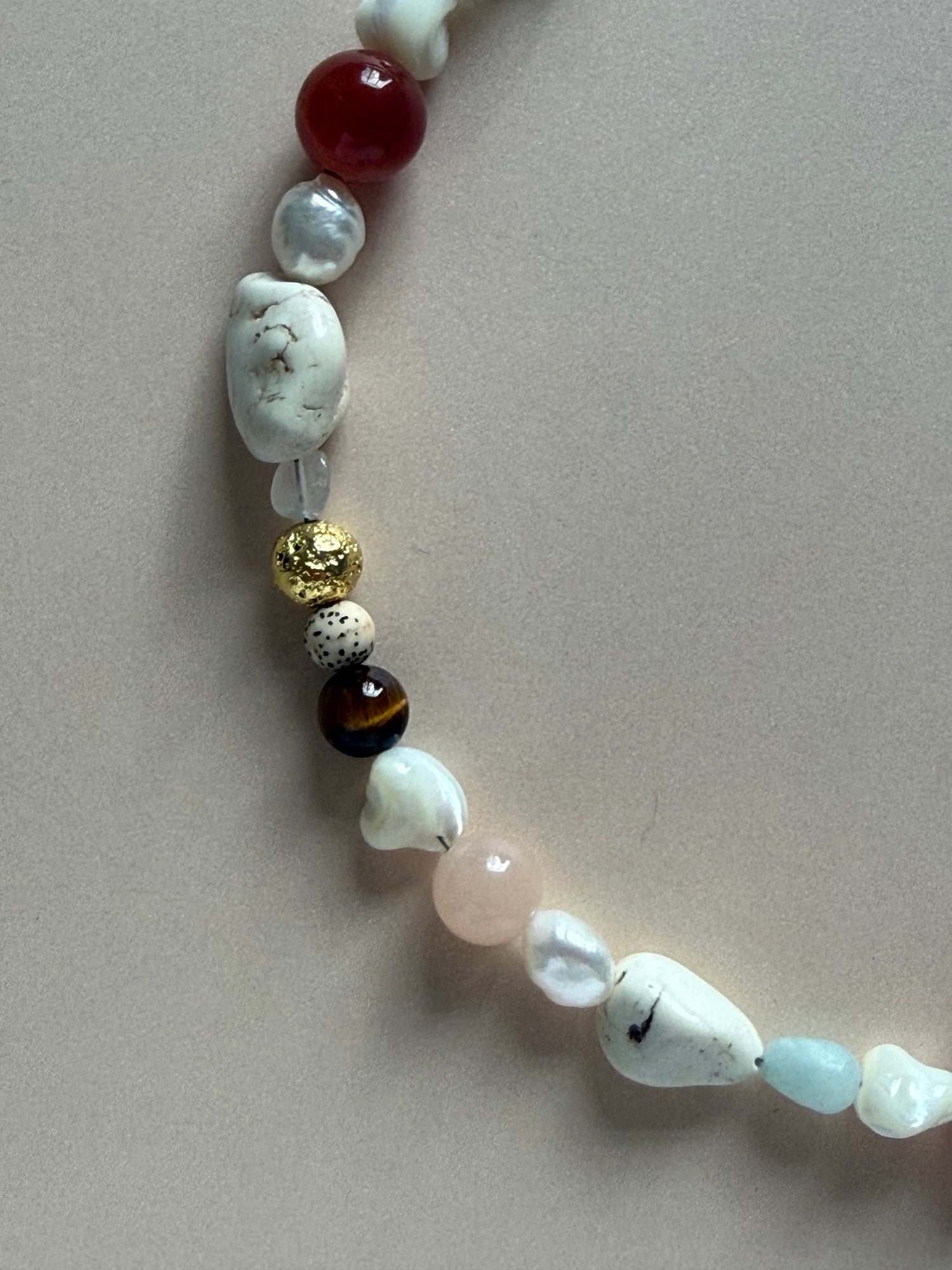 Necklace with various beads on a neutral background