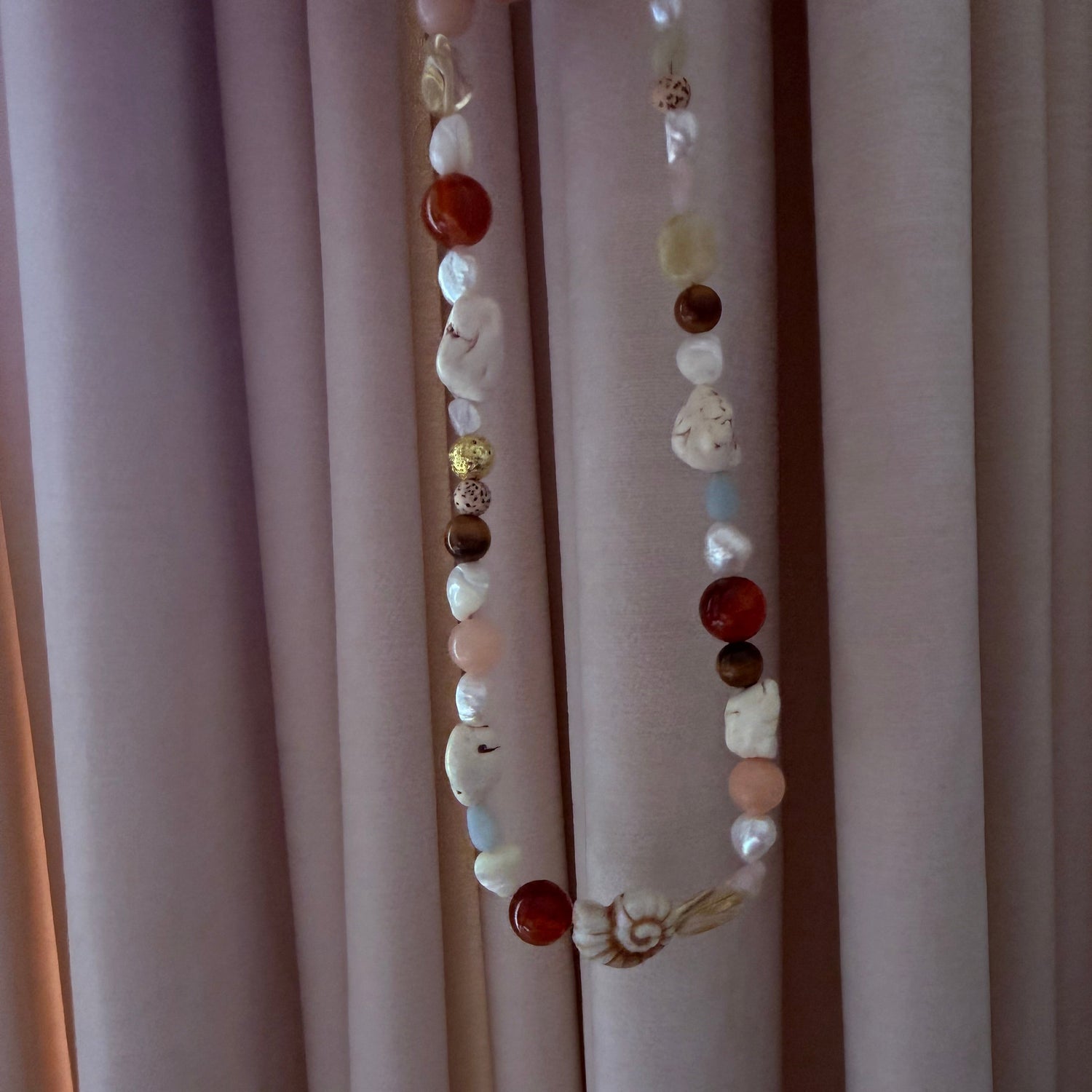 Multicolored beaded necklace on a plain background