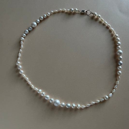 Pearl necklace on a beige surface