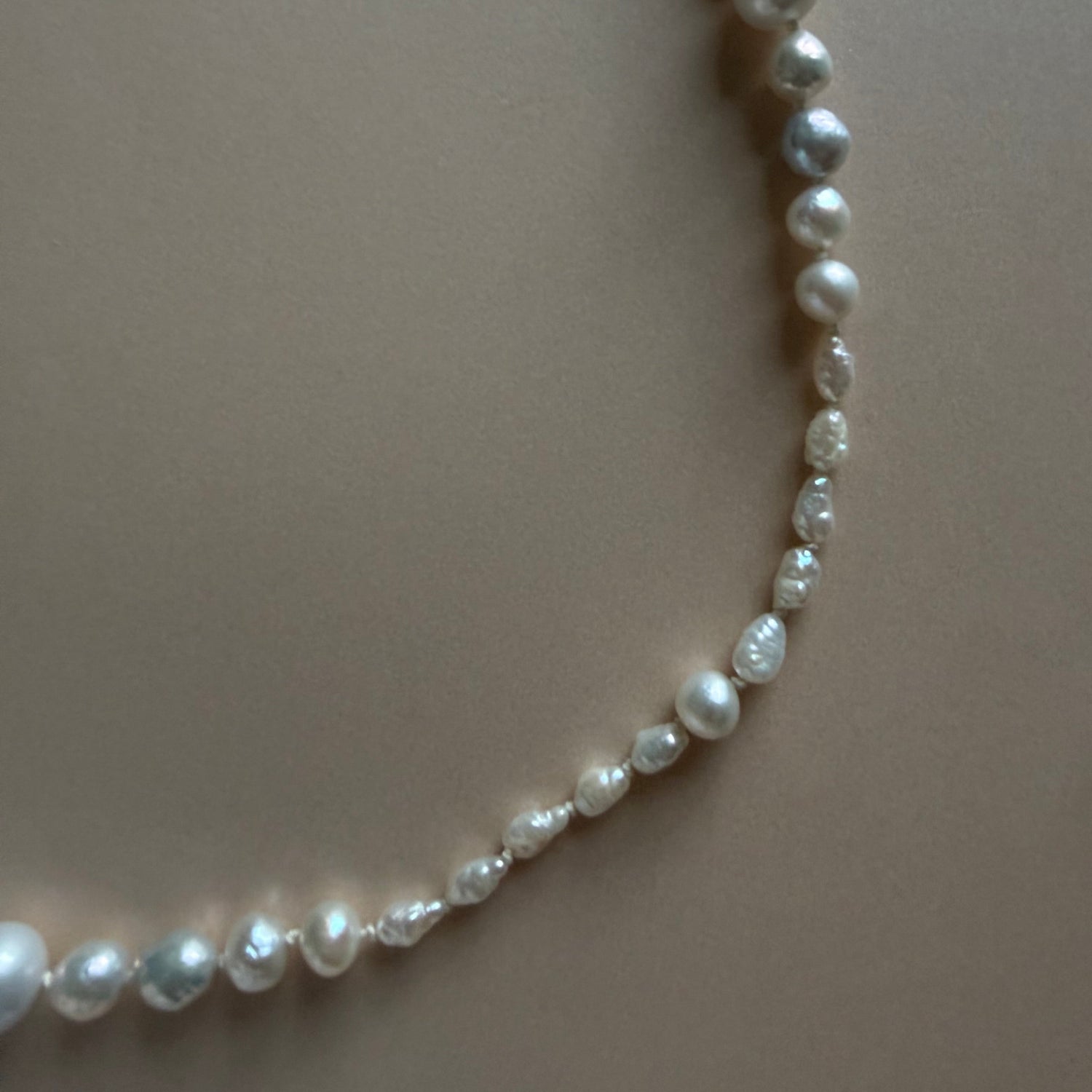 Pearl necklace on a plain background