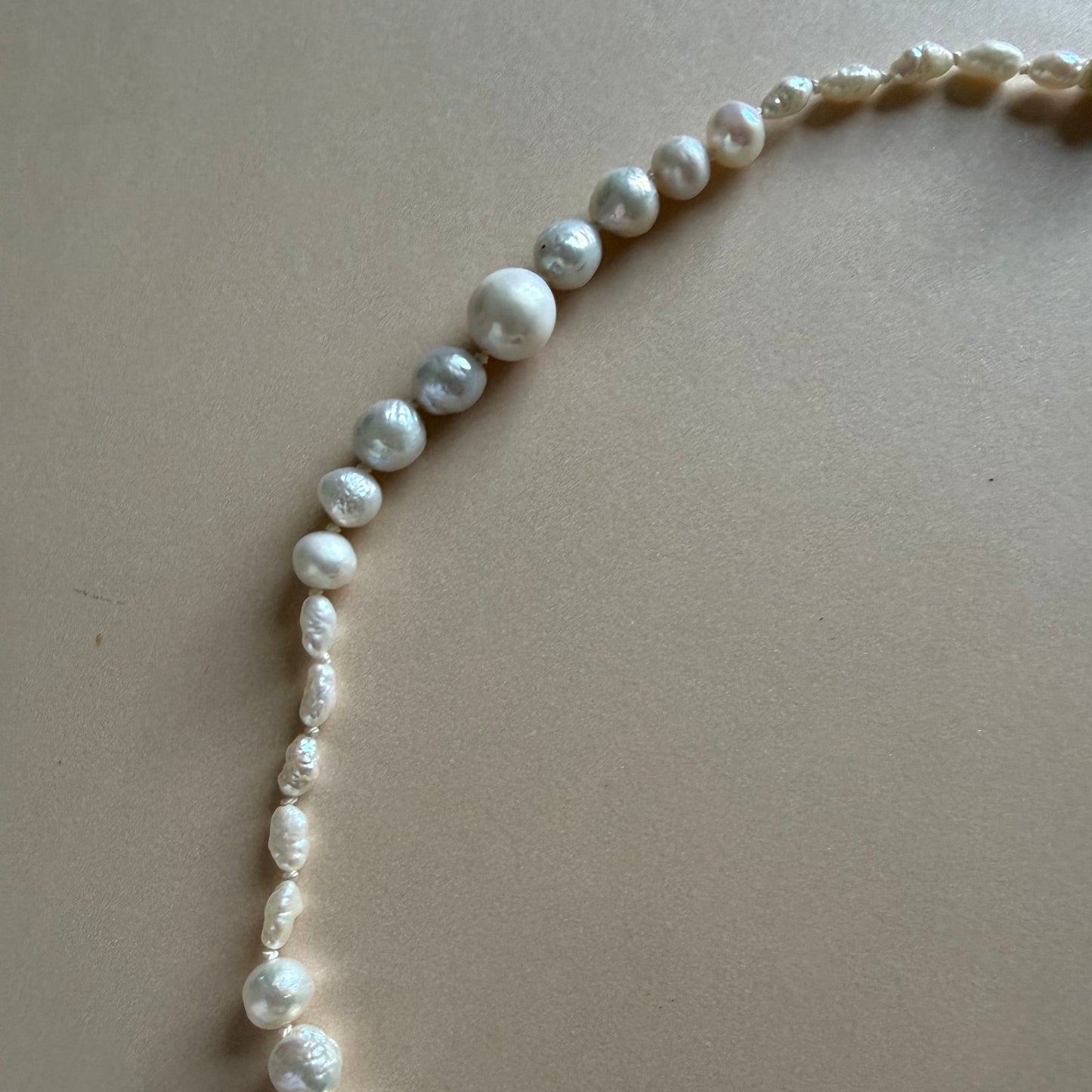 Pearl necklace on a light beige background