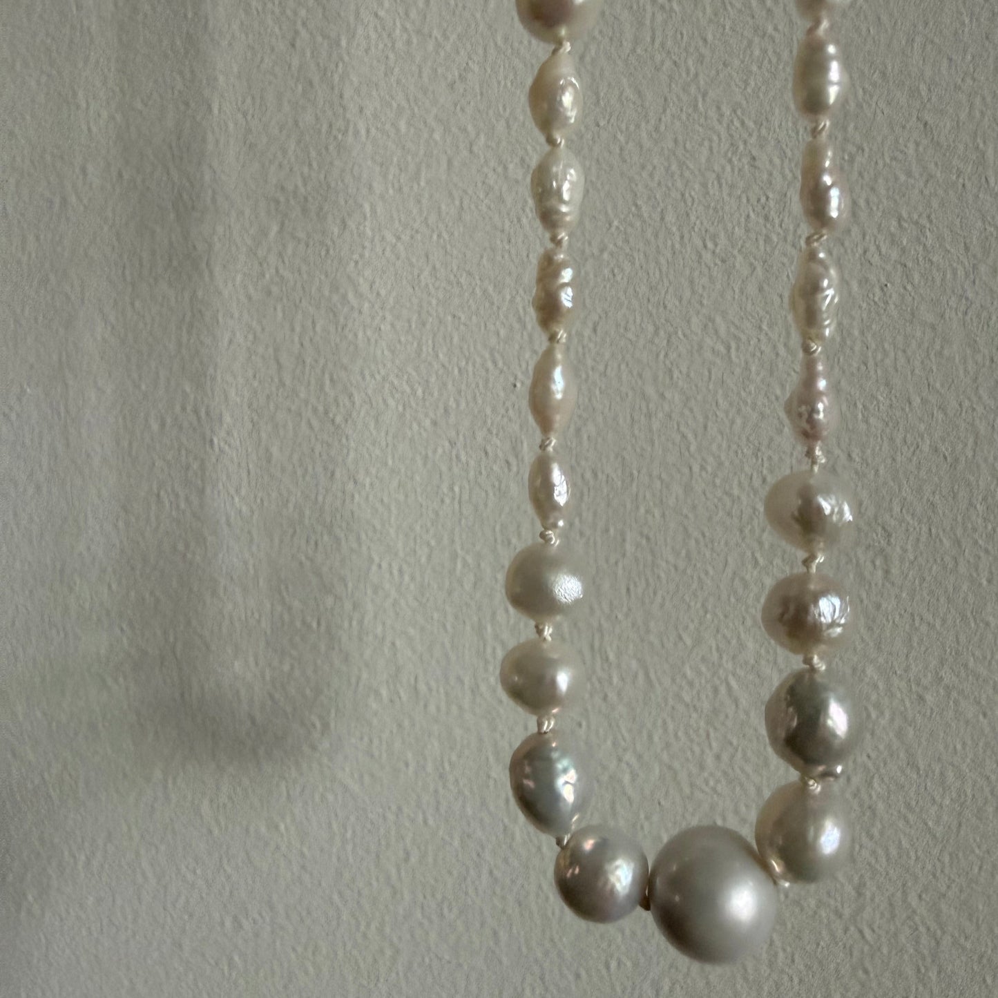 Pearl necklace on a textured white surface