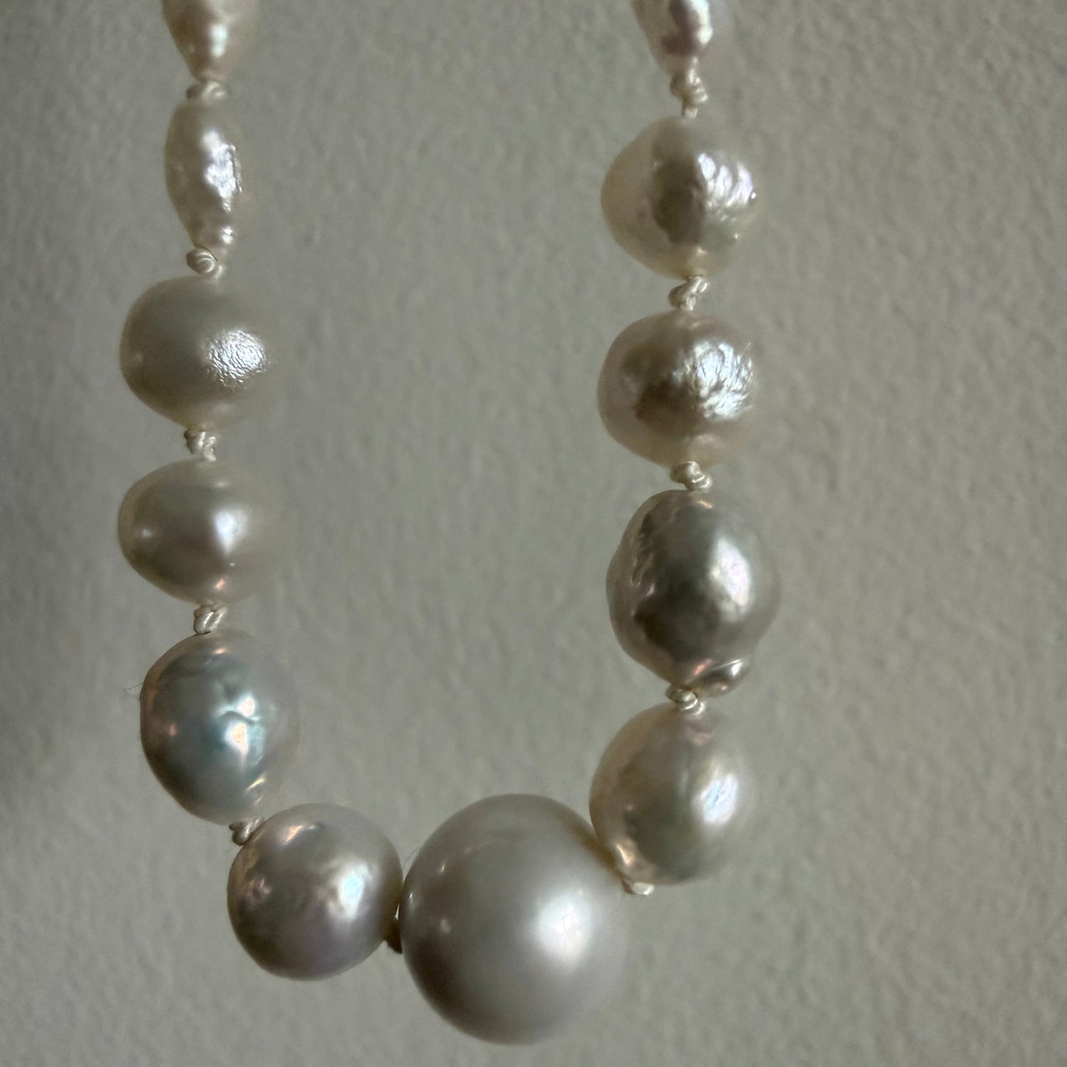 Pearl necklace on a textured light gray background
