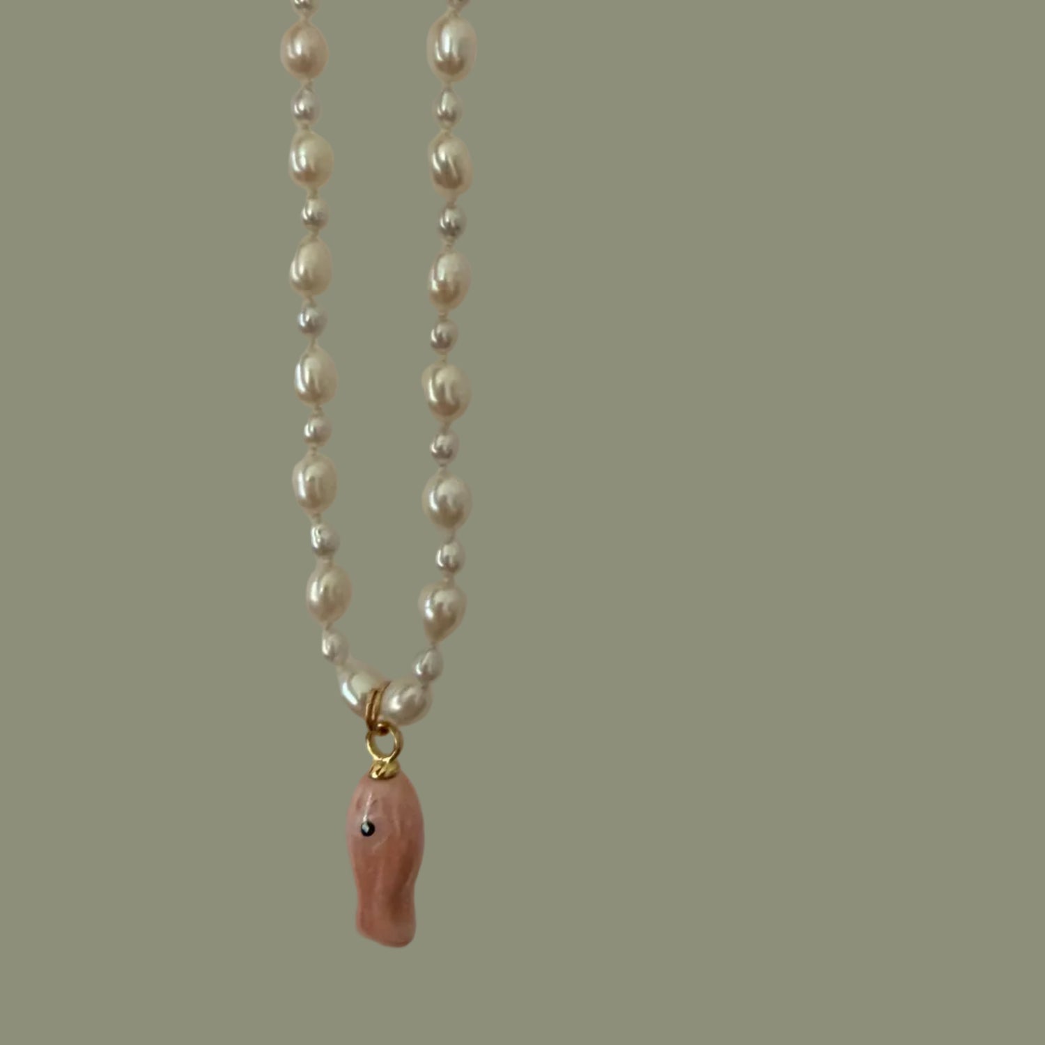 Pearl necklace with a pink pendant on a plain background