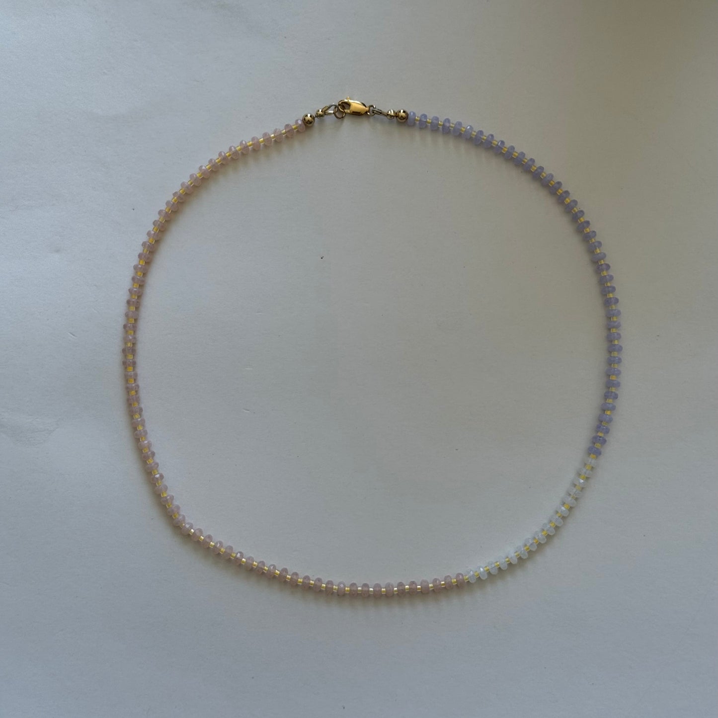 Necklace with small beads on a light gray background