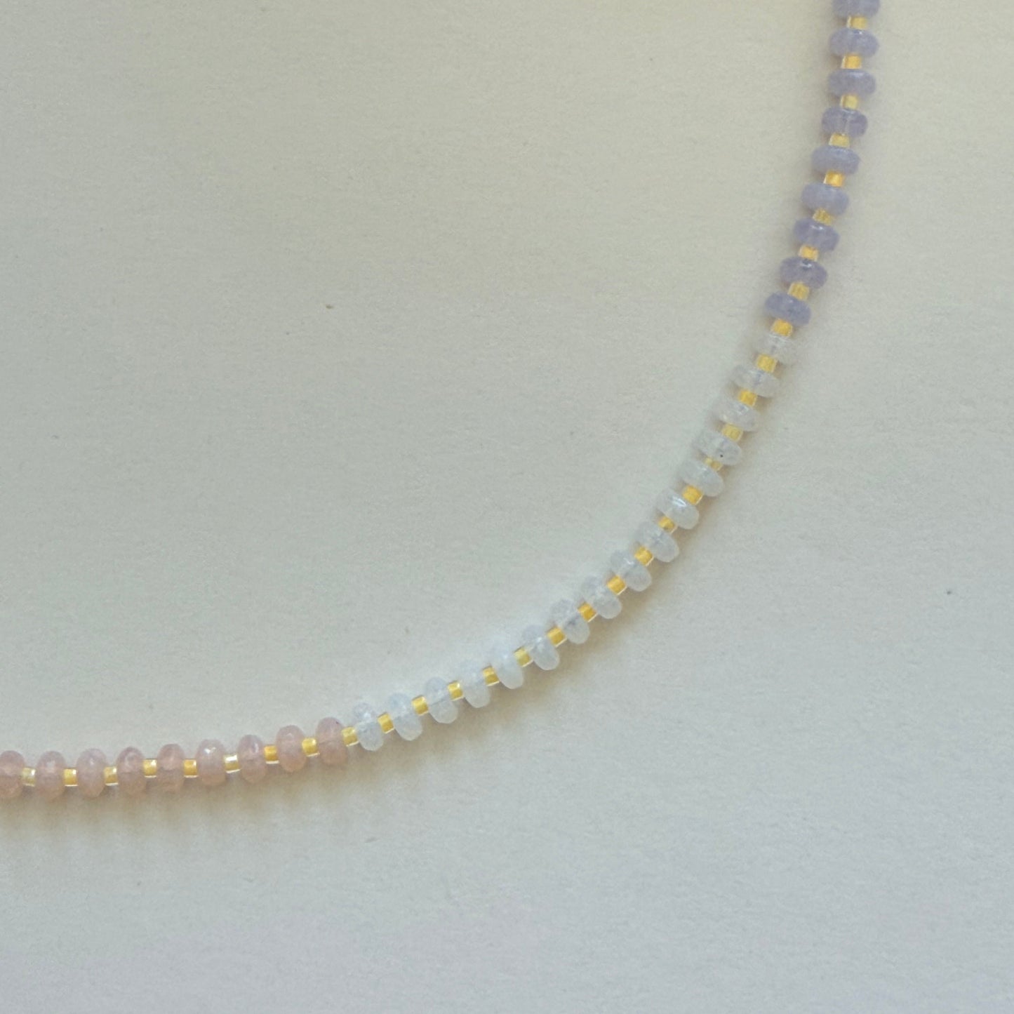 Necklace with small beads on a light gray background