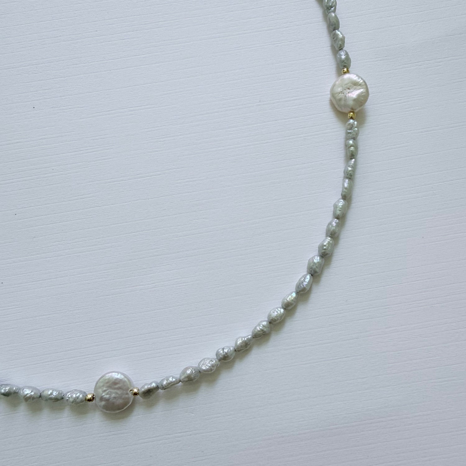 Pearl necklace on a light gray background