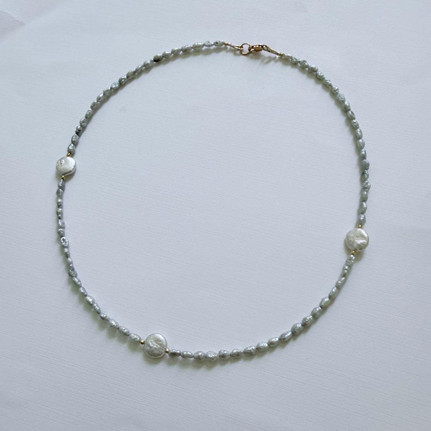 Pearl necklace on a light gray background