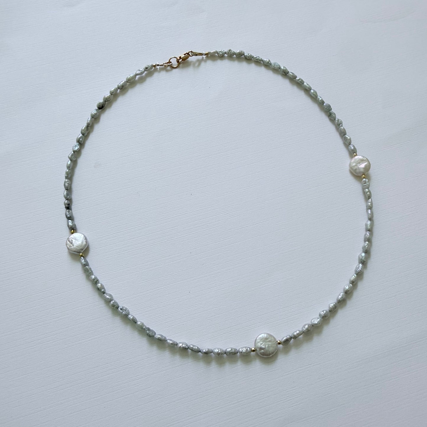 Pearl necklace on a light gray background