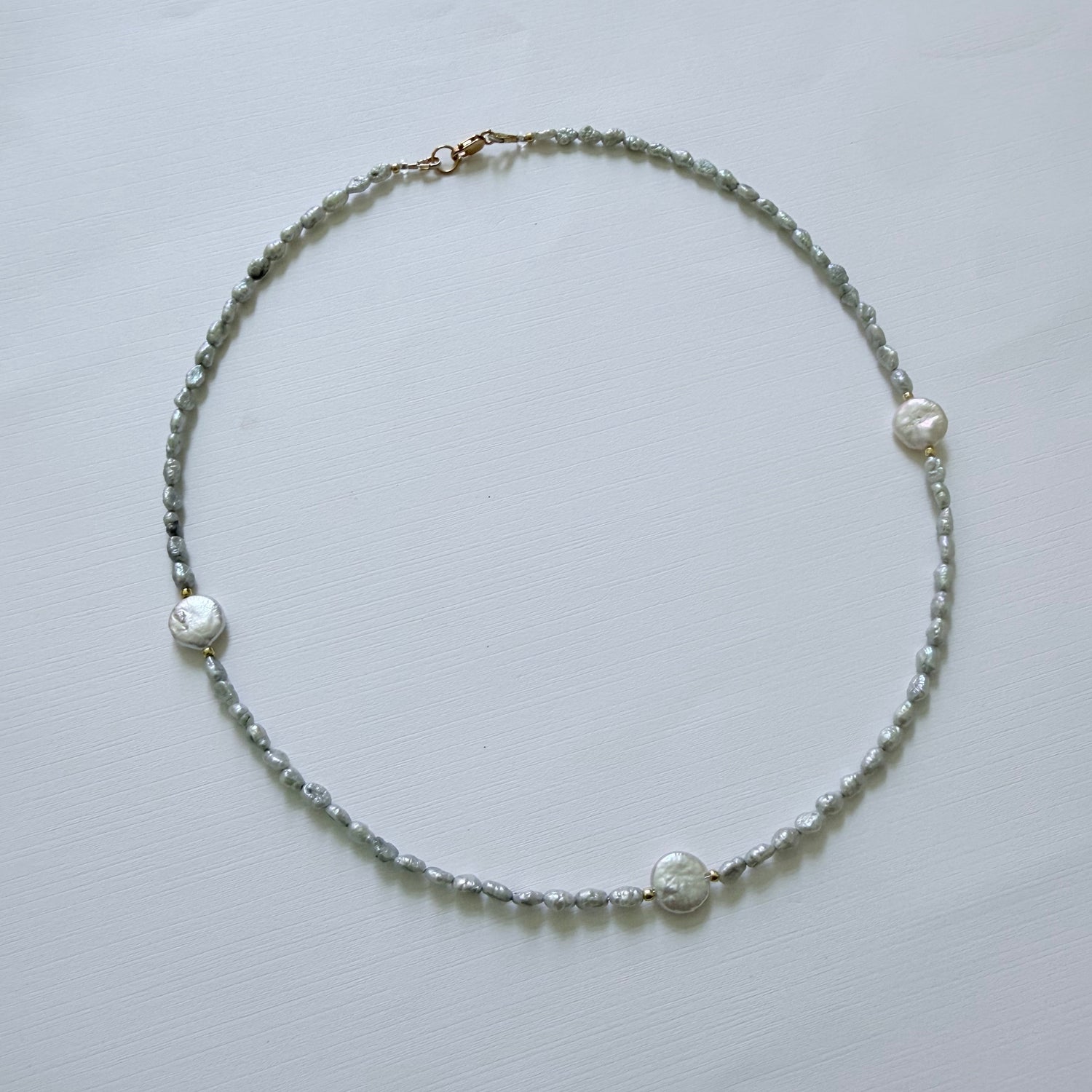 Pearl necklace on a light gray background