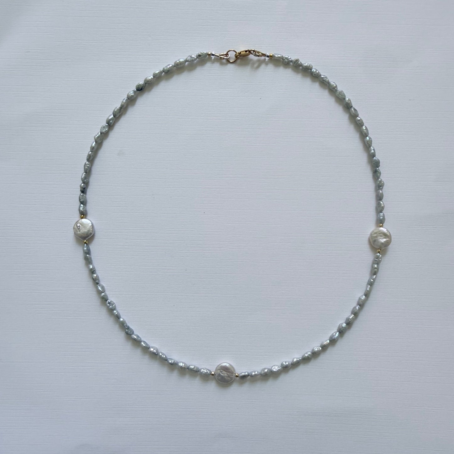 Necklace with small beads on a light gray background