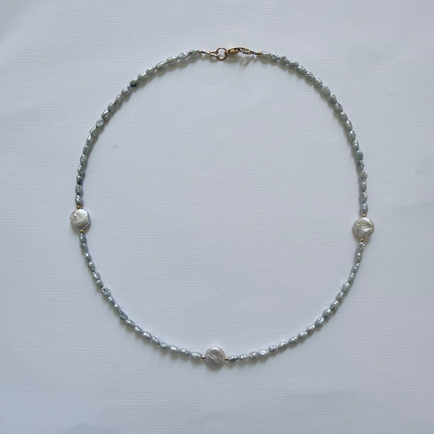 Necklace with small beads on a light gray background