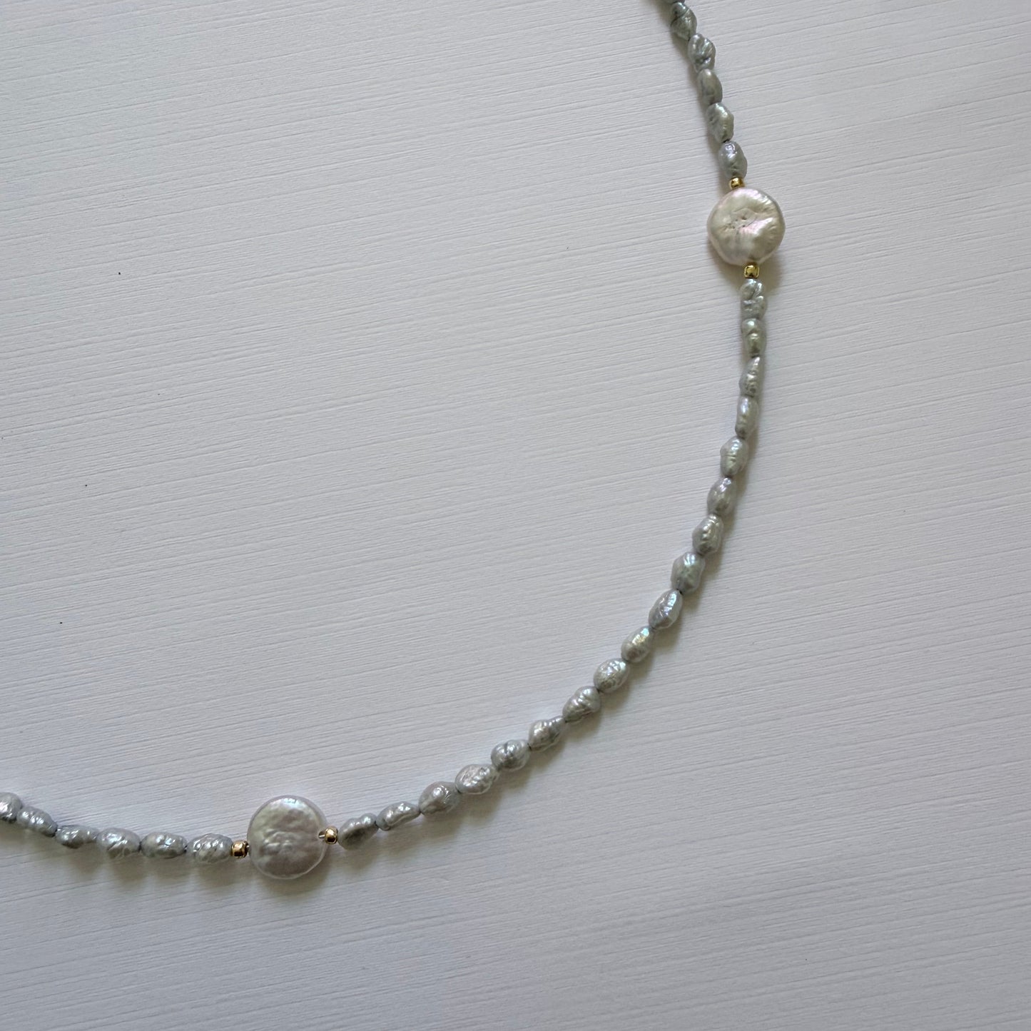 Pearl necklace on a light gray background