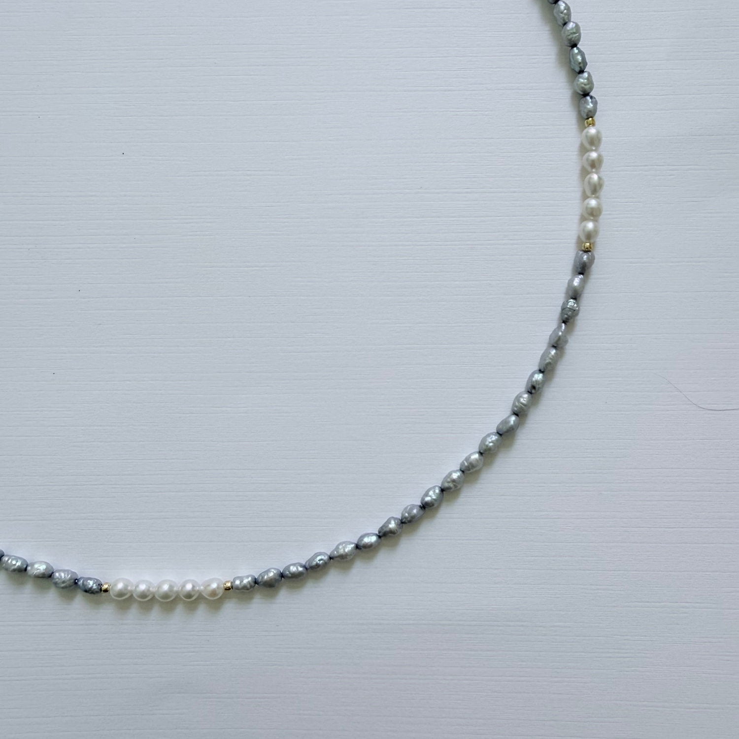 Pearl necklace on a light gray background