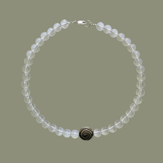 Beaded necklace with a dark clasp on a light gray background