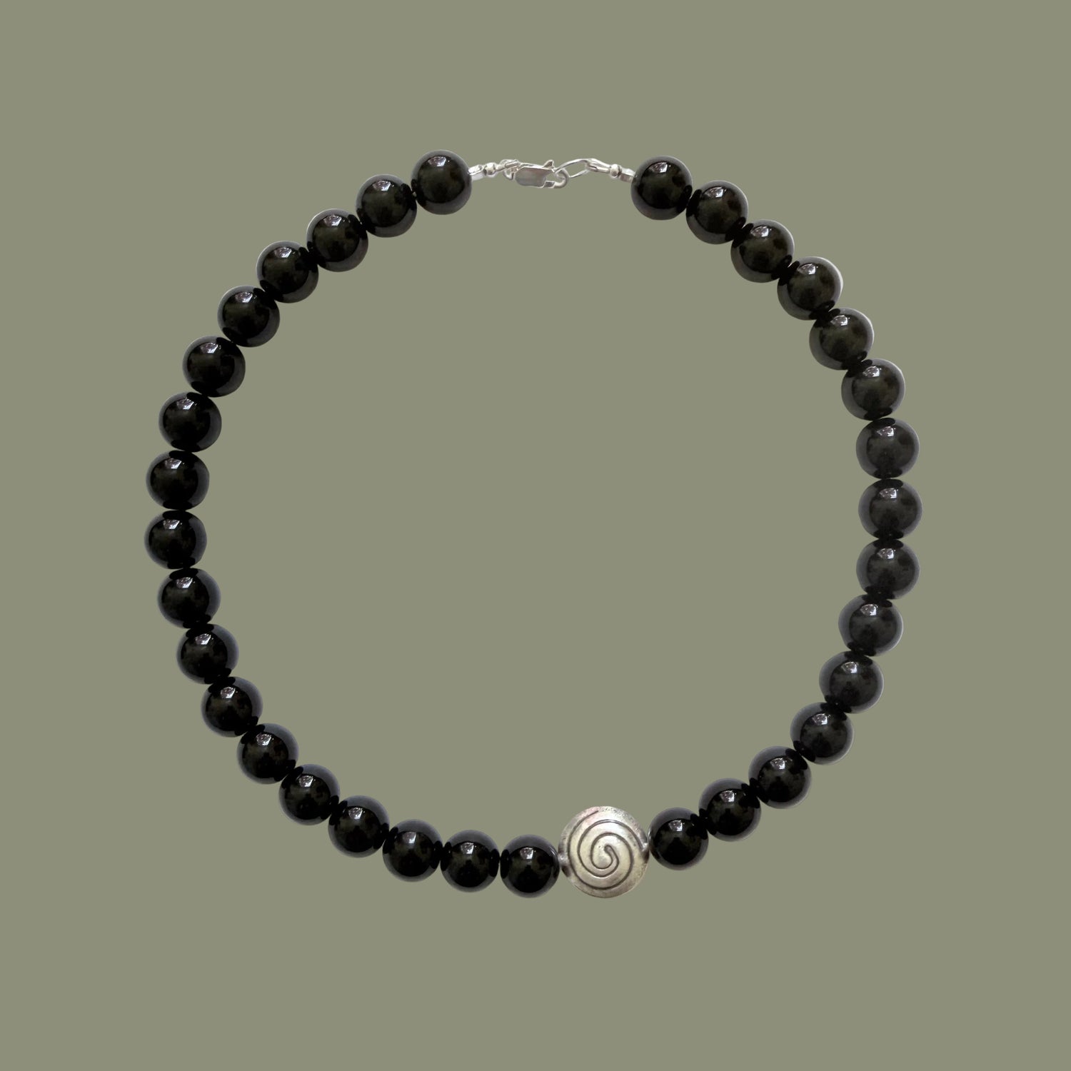 Black beaded necklace with a silver clasp on a white background