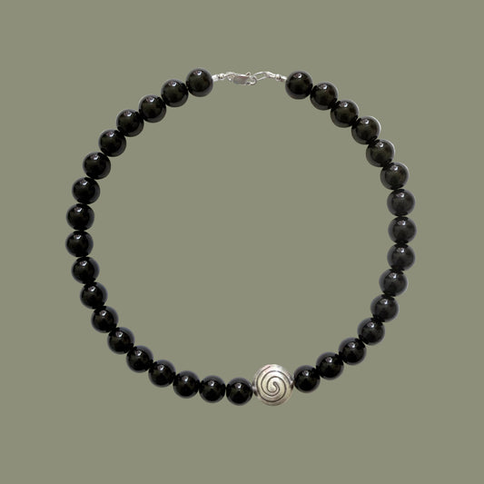 Black beaded necklace with a silver clasp on a white background