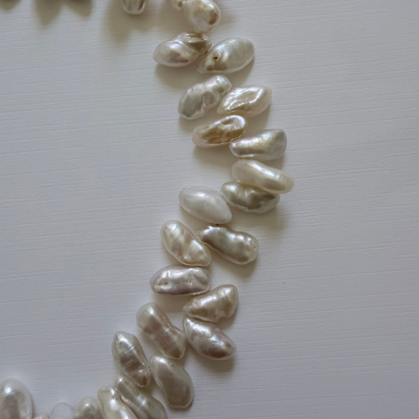 Pearl necklace on a light gray background