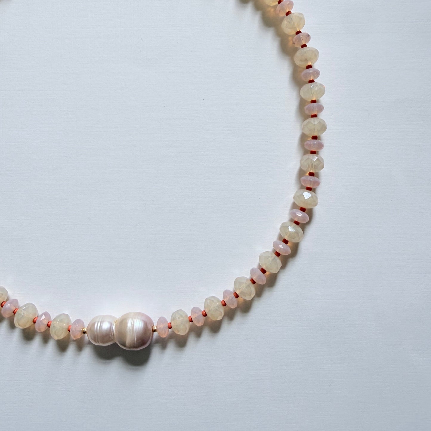 Pearl necklace on a light gray background