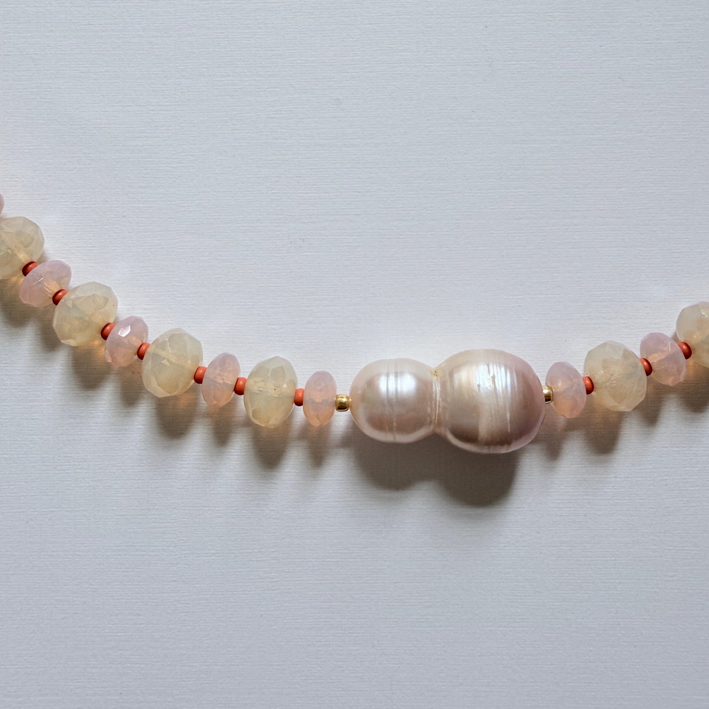 Necklace with pearls and moonstones on a light gray background