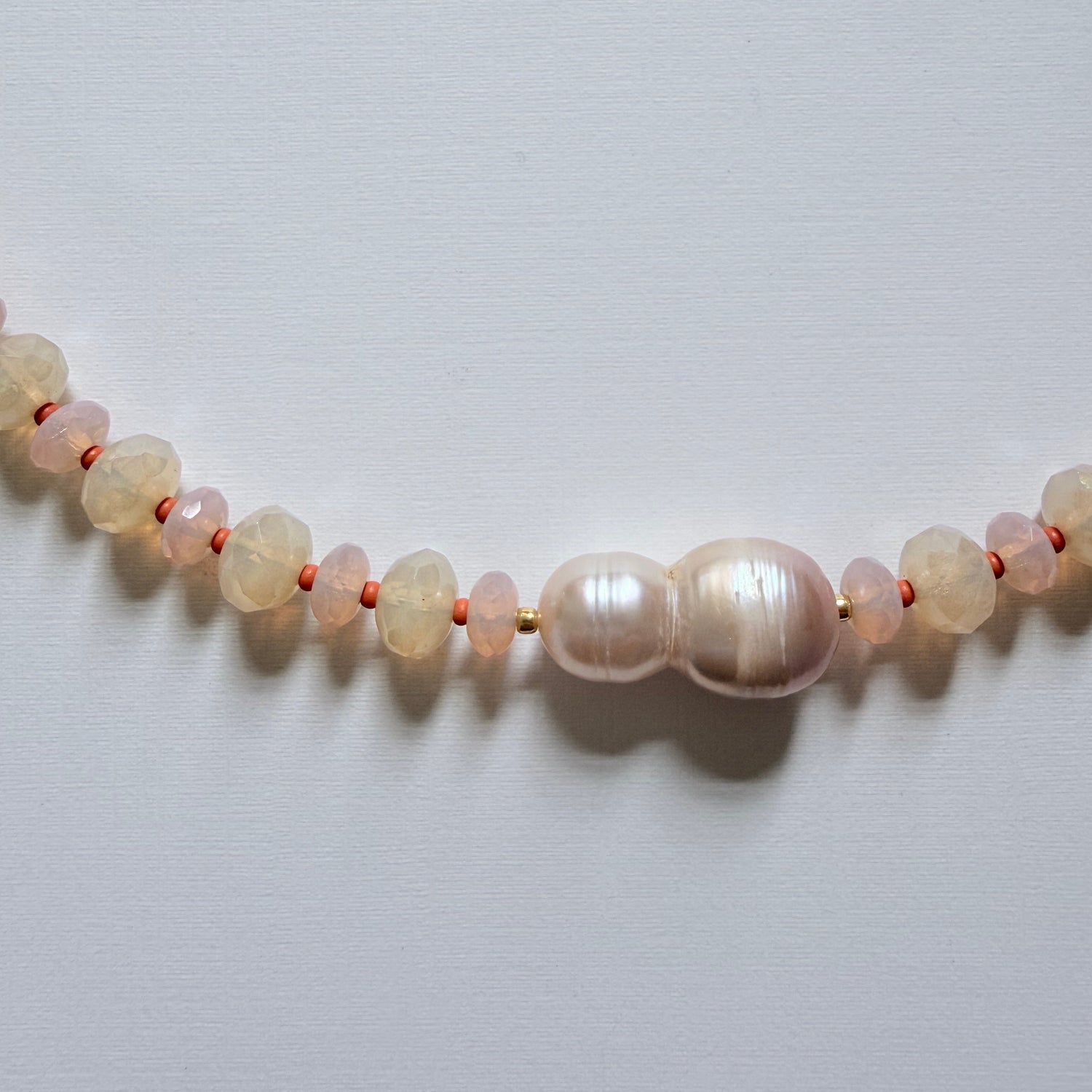 Necklace with pearls and moonstones on a light gray background
