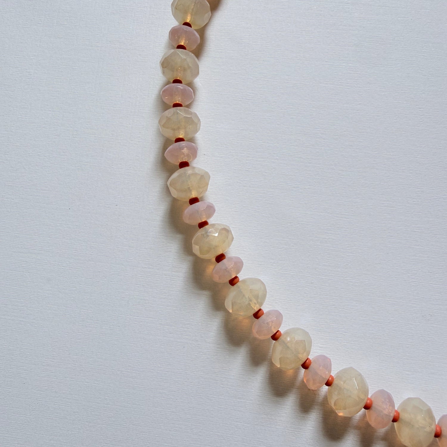 Necklace with small beads on a light gray background