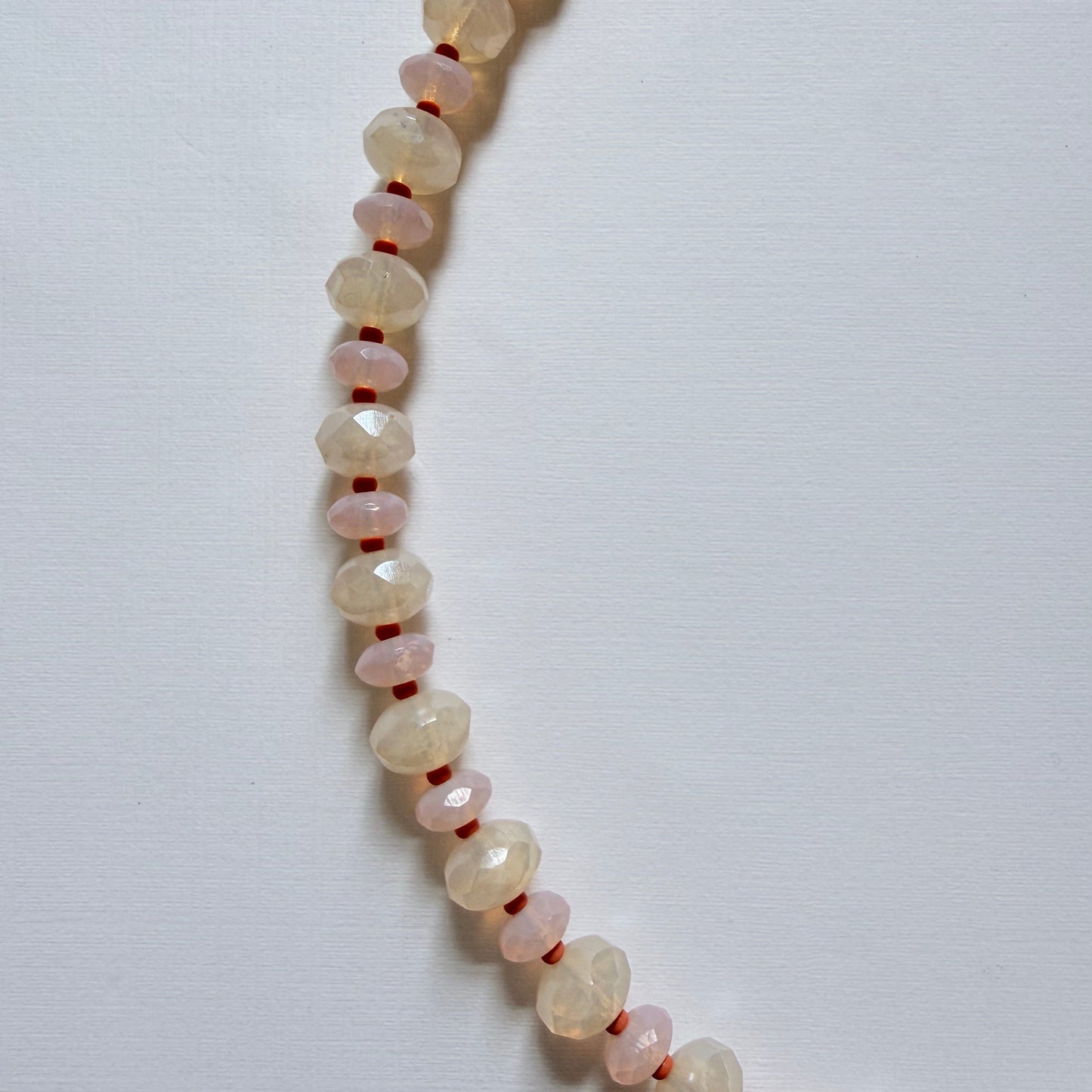 Necklace with small, round, light-colored beads on a white background