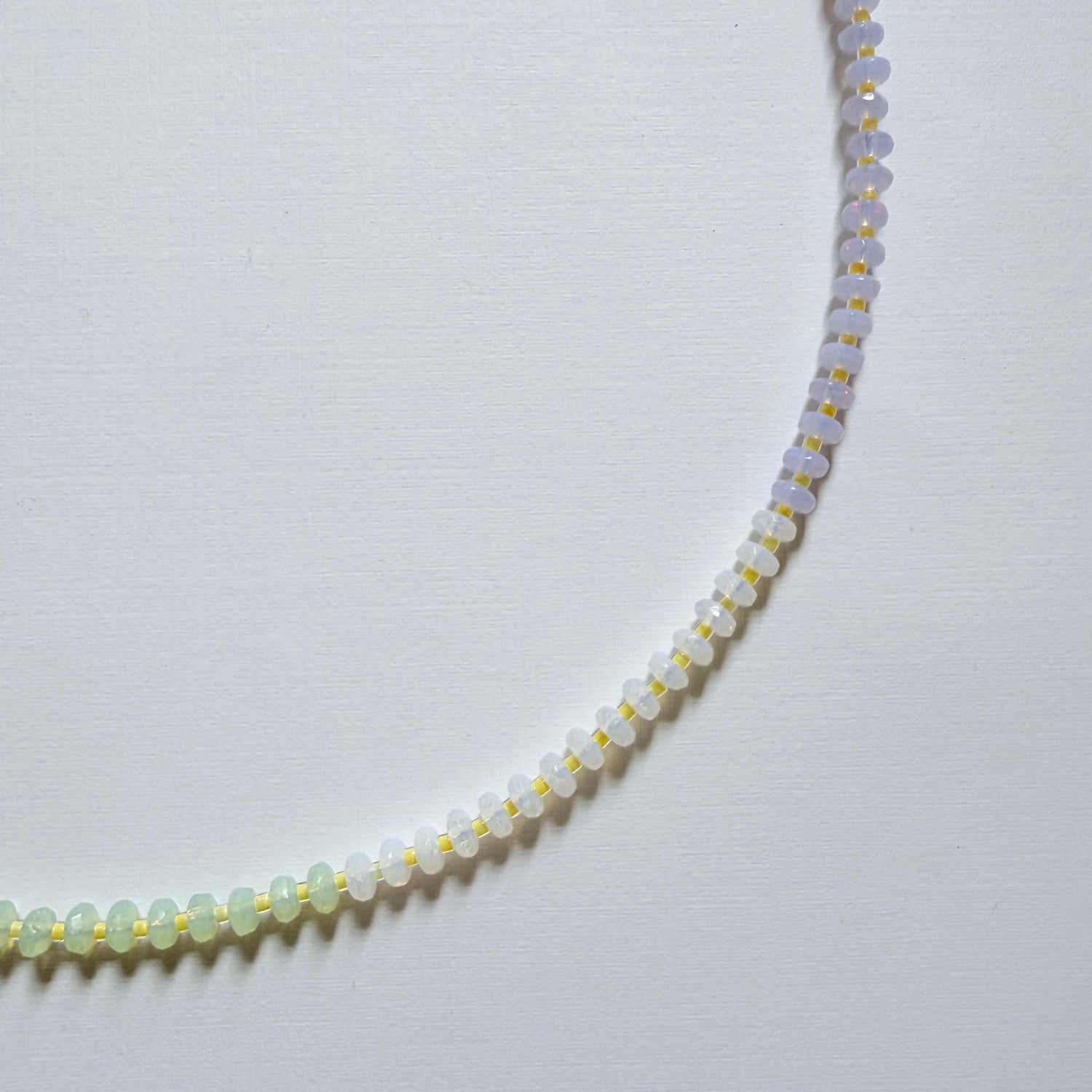 Necklace with small beads on a light gray background