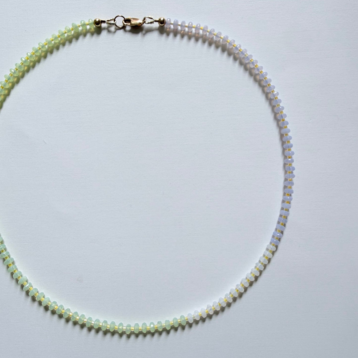 Necklace with alternating beads on a light gray background