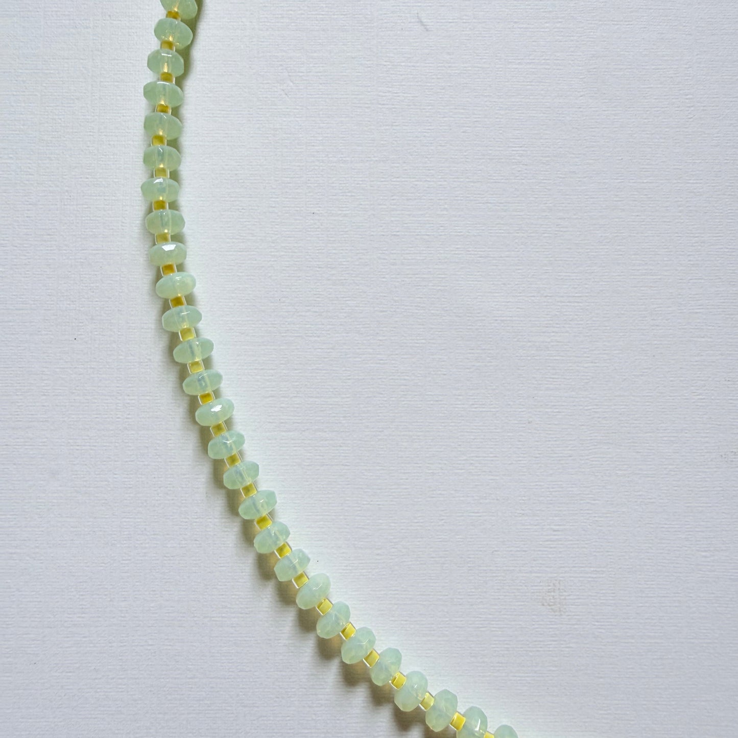 Necklace with light green beads on a white background