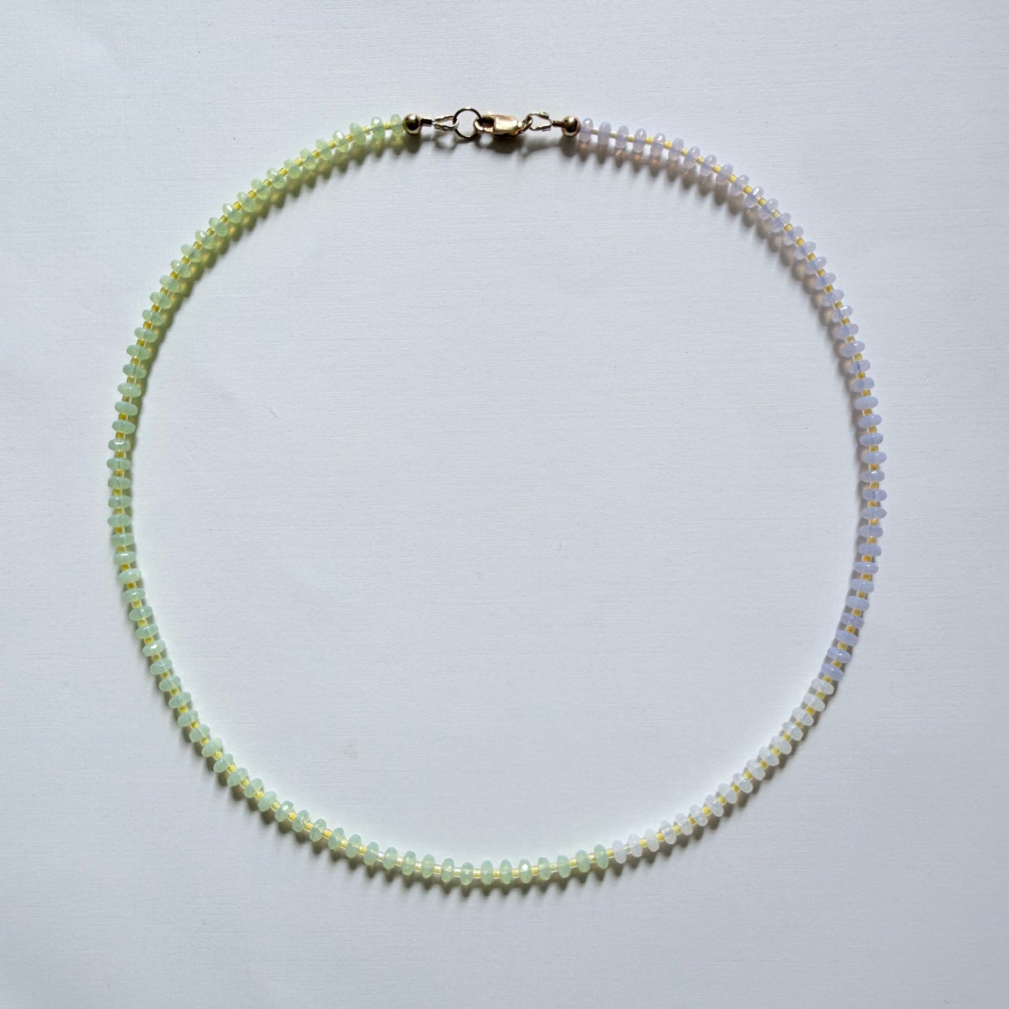 Necklace with small beads on a light gray background