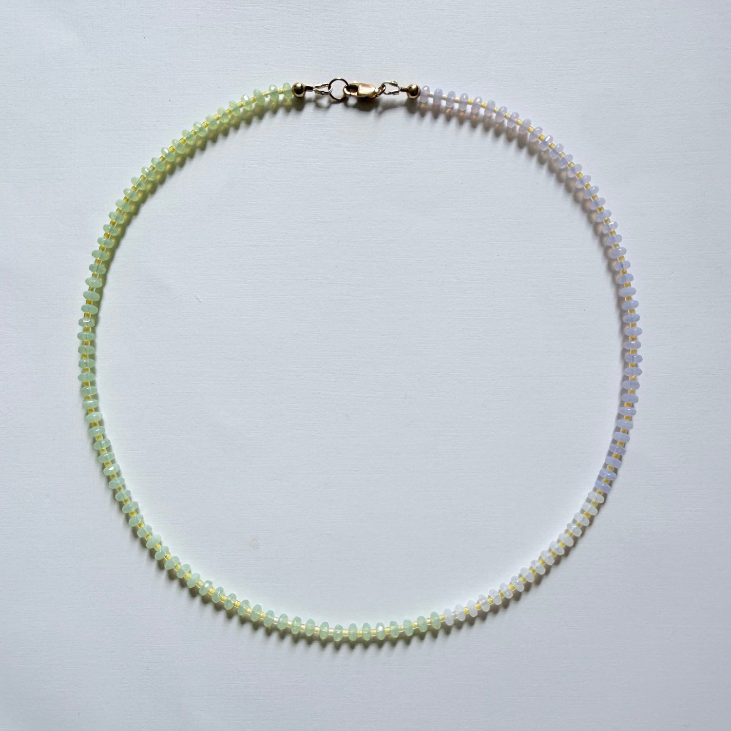 Necklace with small beads on a light gray background