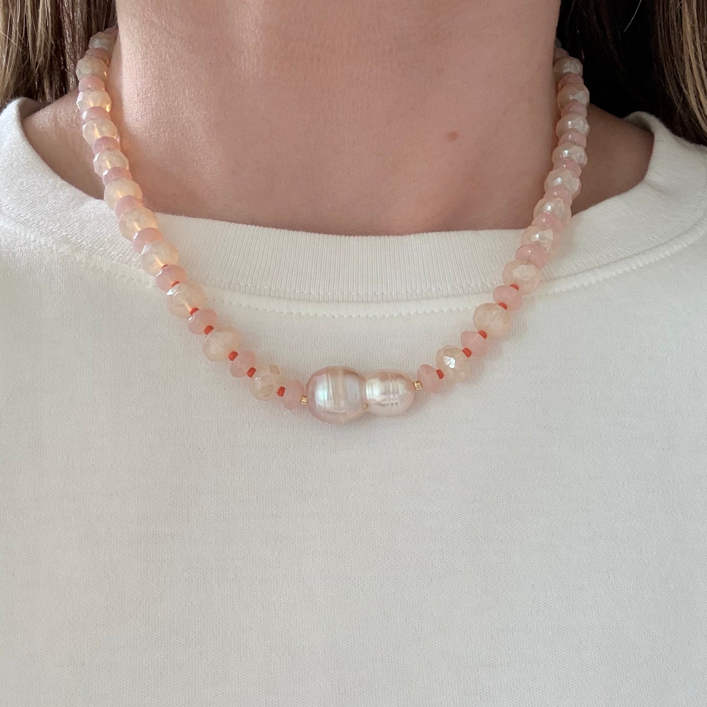 Pearl bracelet on a person's wrist against a plain background