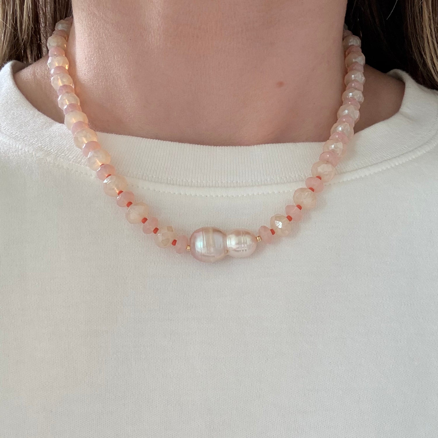 Pearl bracelet on a person's wrist against a plain background