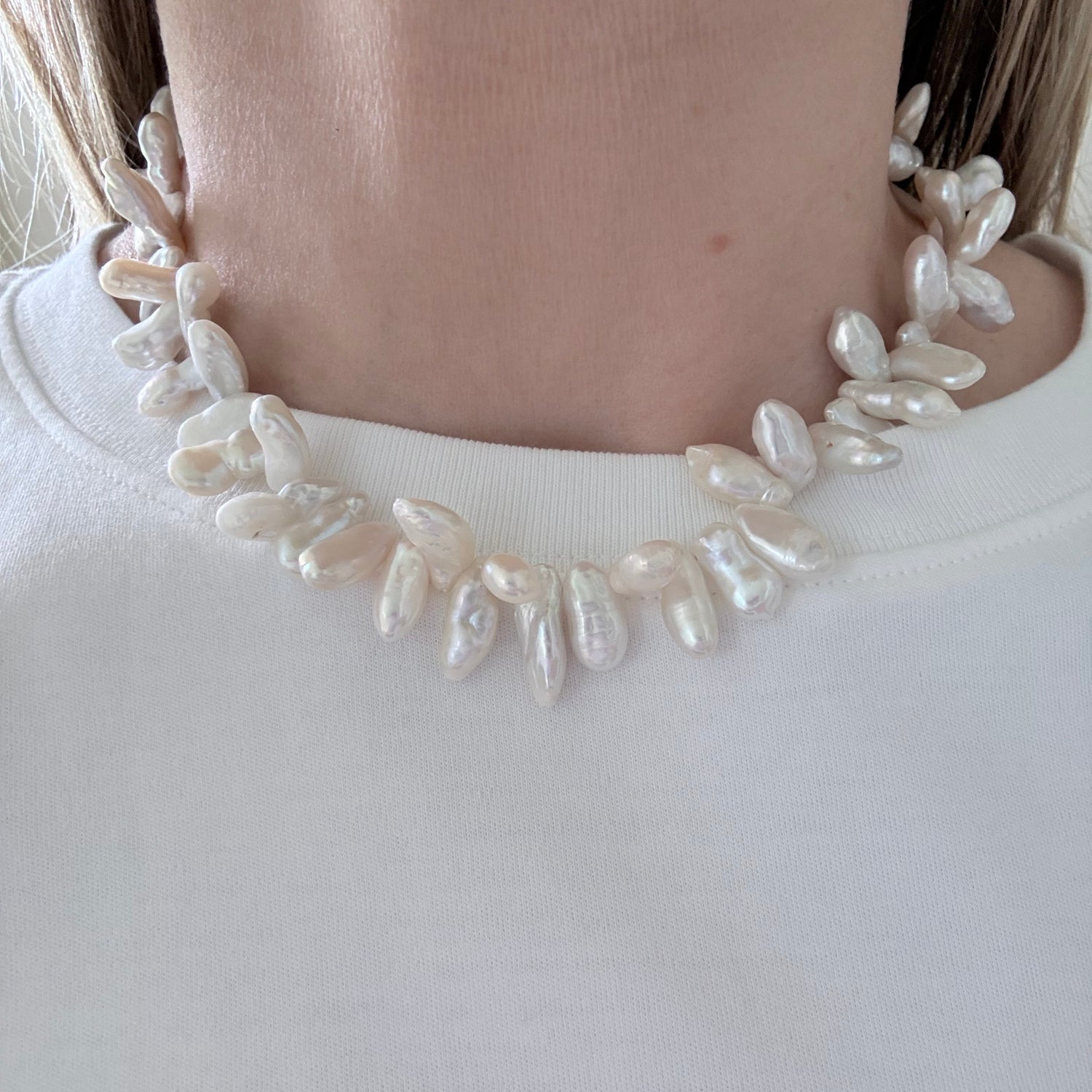 Pearl headband worn by a person on a plain background