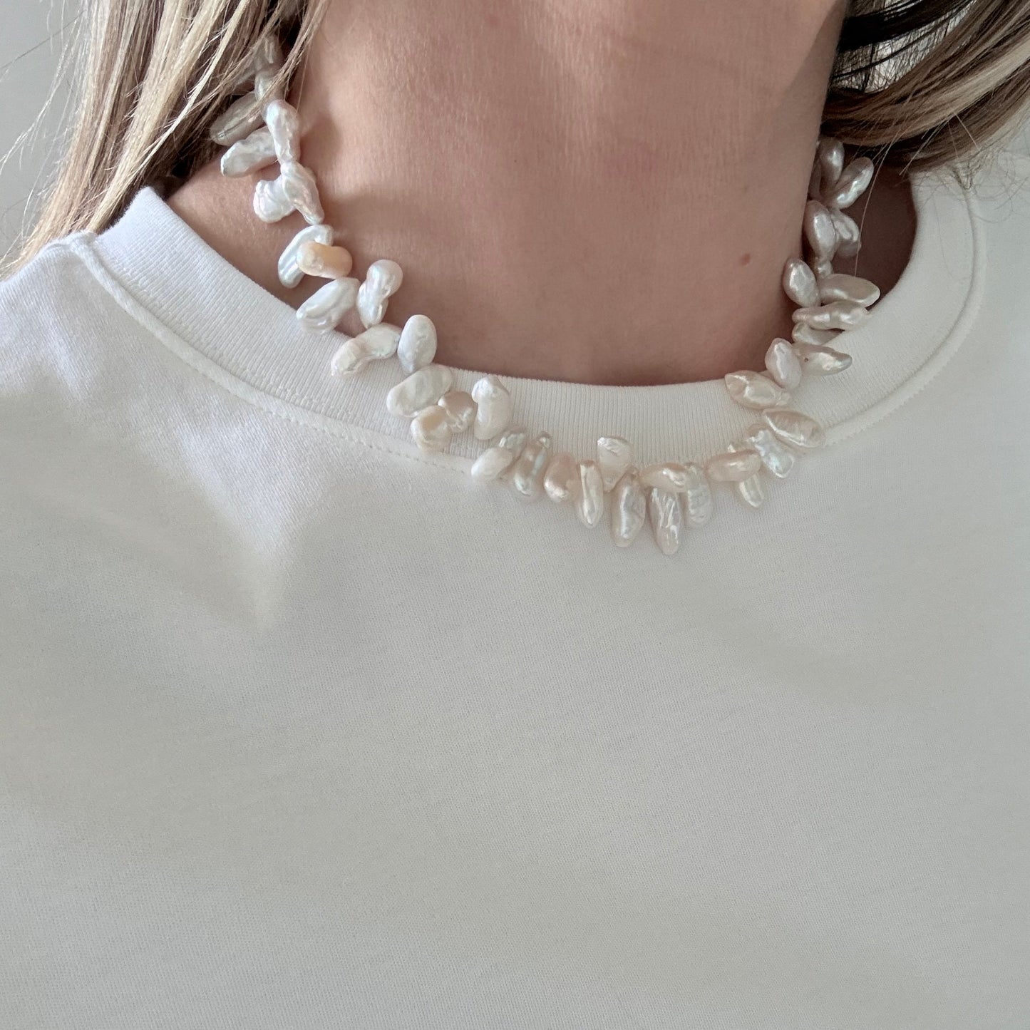 Pearl headband worn by a person on a plain background