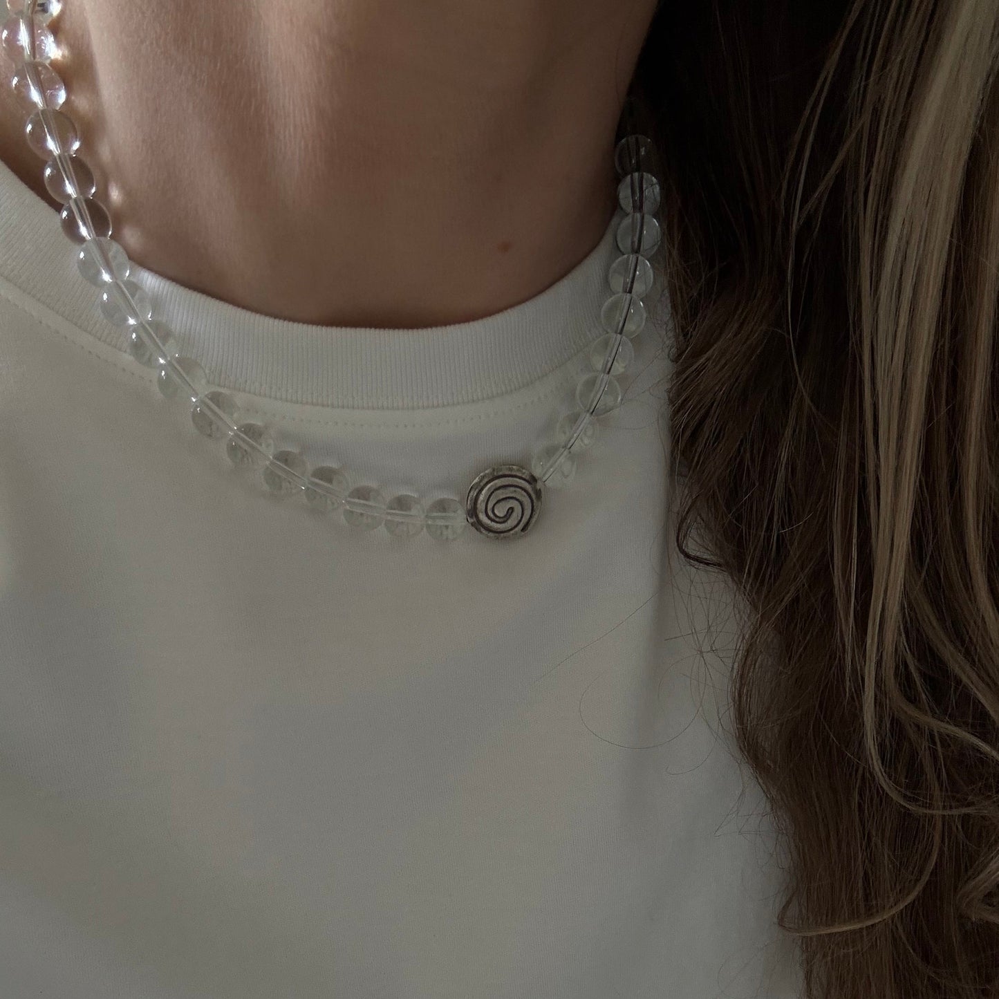 Close-up of a white blouse with decorative trim and a person's hair.