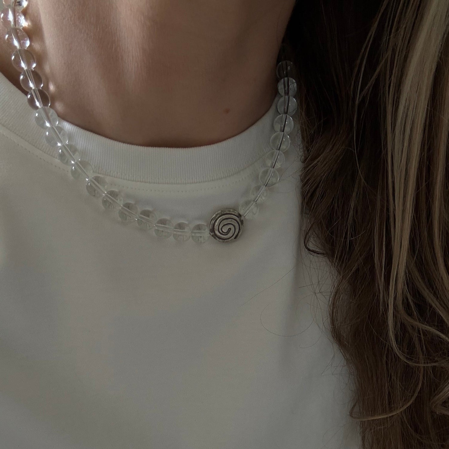 Close-up of a white blouse with decorative trim and a person's hair.
