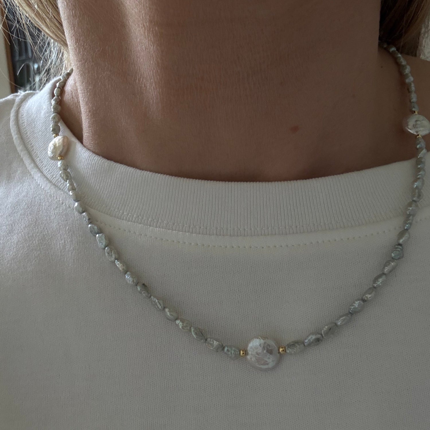 Close-up of a pearl necklace on a plain background