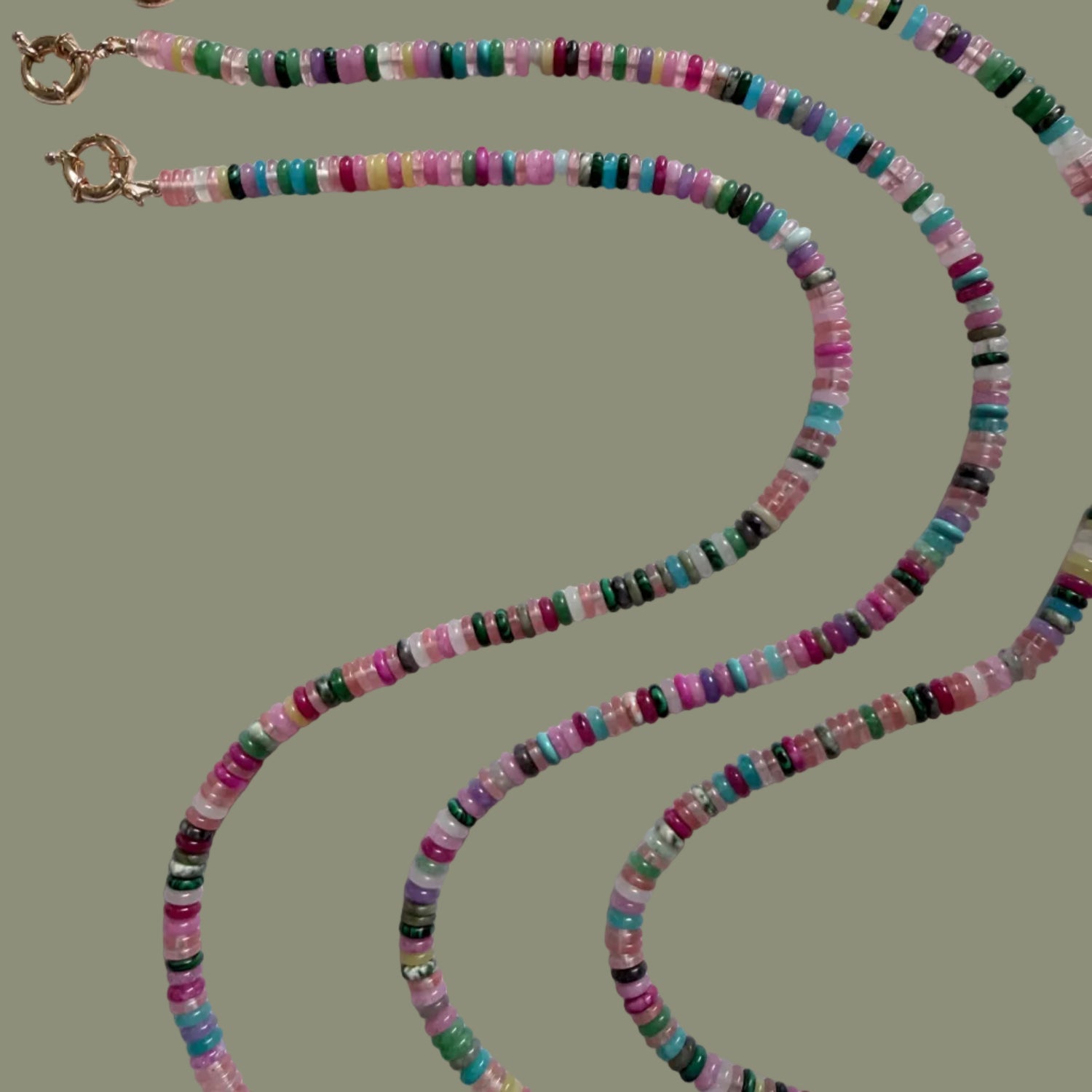 Multicolored beaded necklace with gold pendants on a white background
