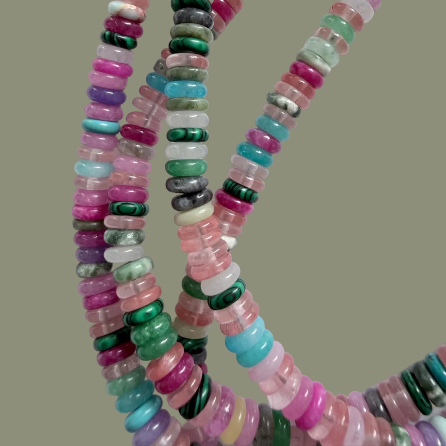 Multicolored bead necklace on a white fabric background