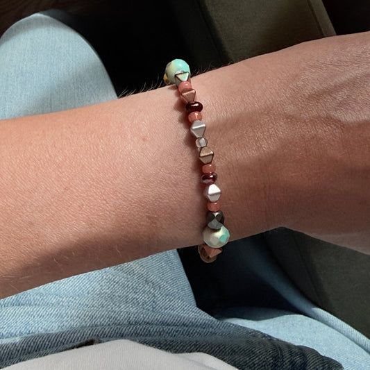 Close-up of a wrist wearing a beaded bracelet with a blurred background