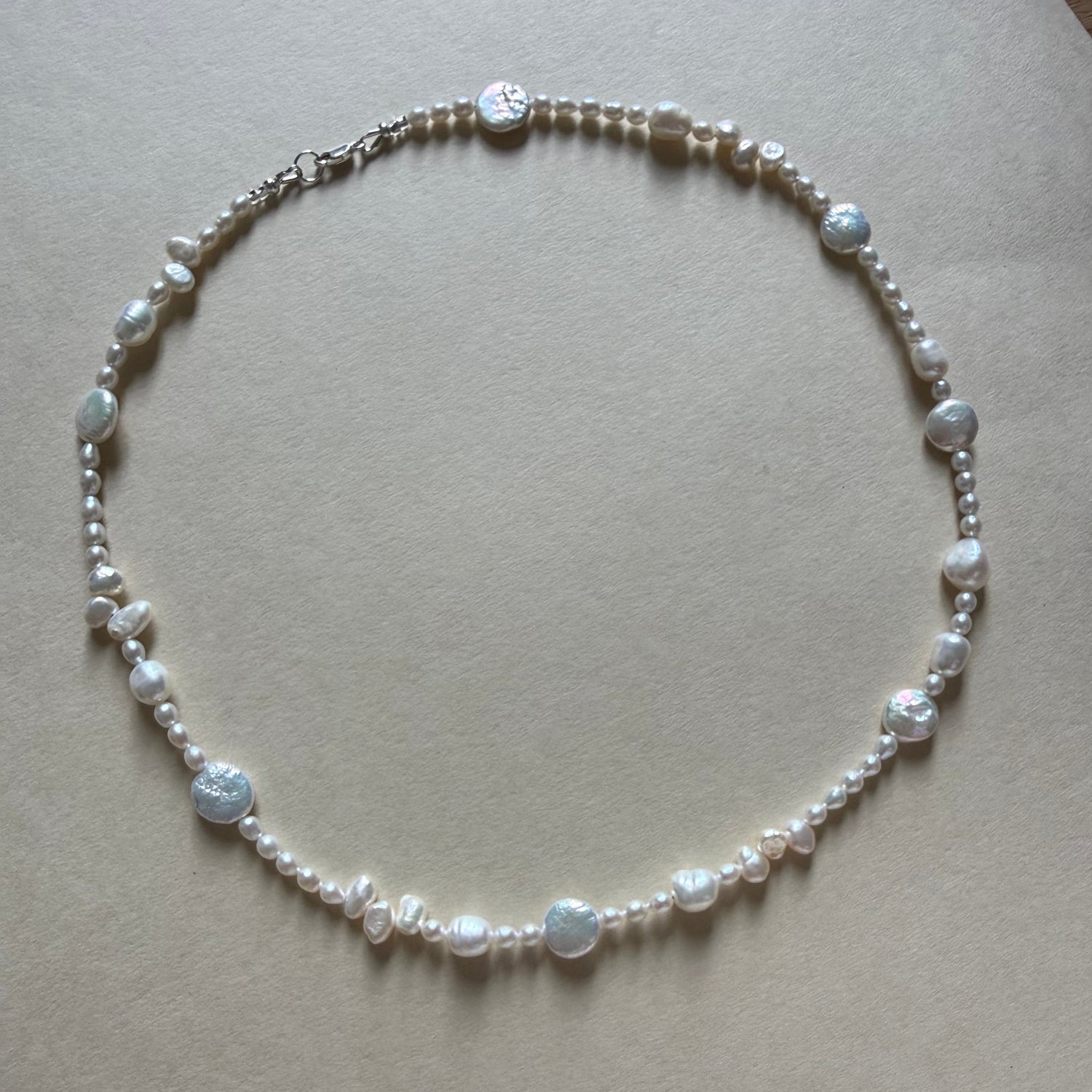 Pearl necklace on a beige background