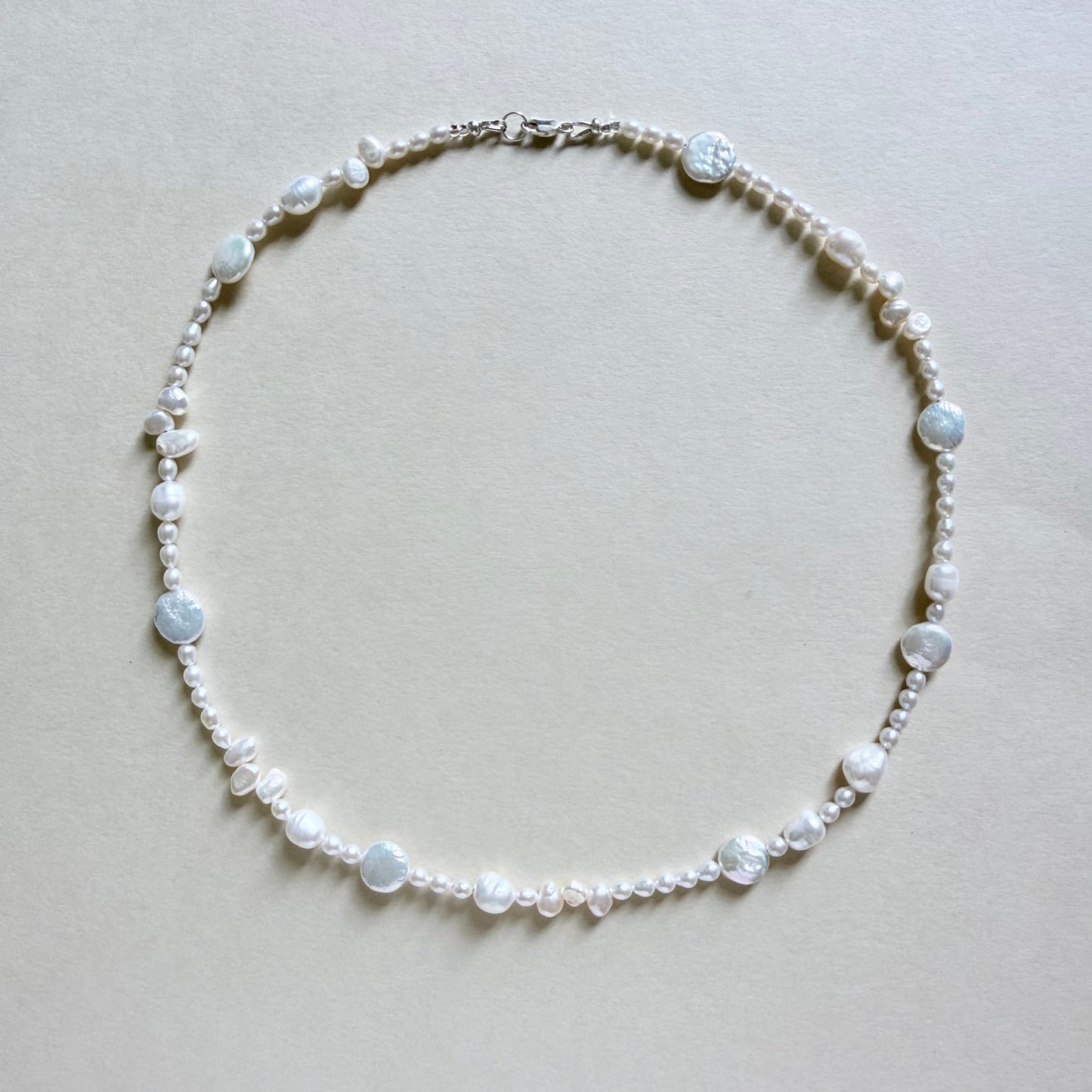 Pearl necklace on a light beige background