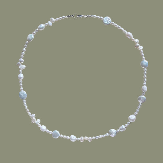 Pearl necklace on a light beige background